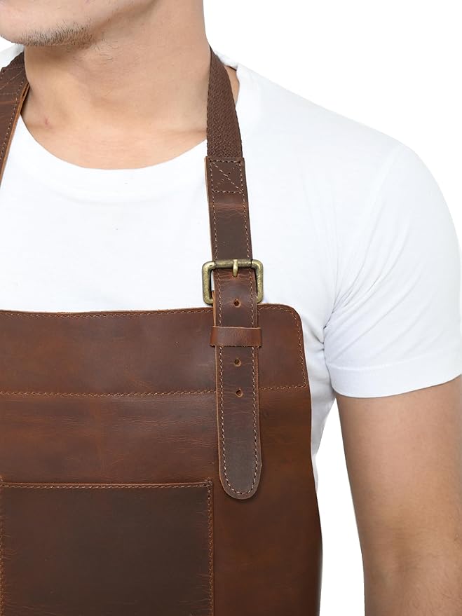 Close-up of adjustable leather shoulder strap and brass buckle on brown work apron