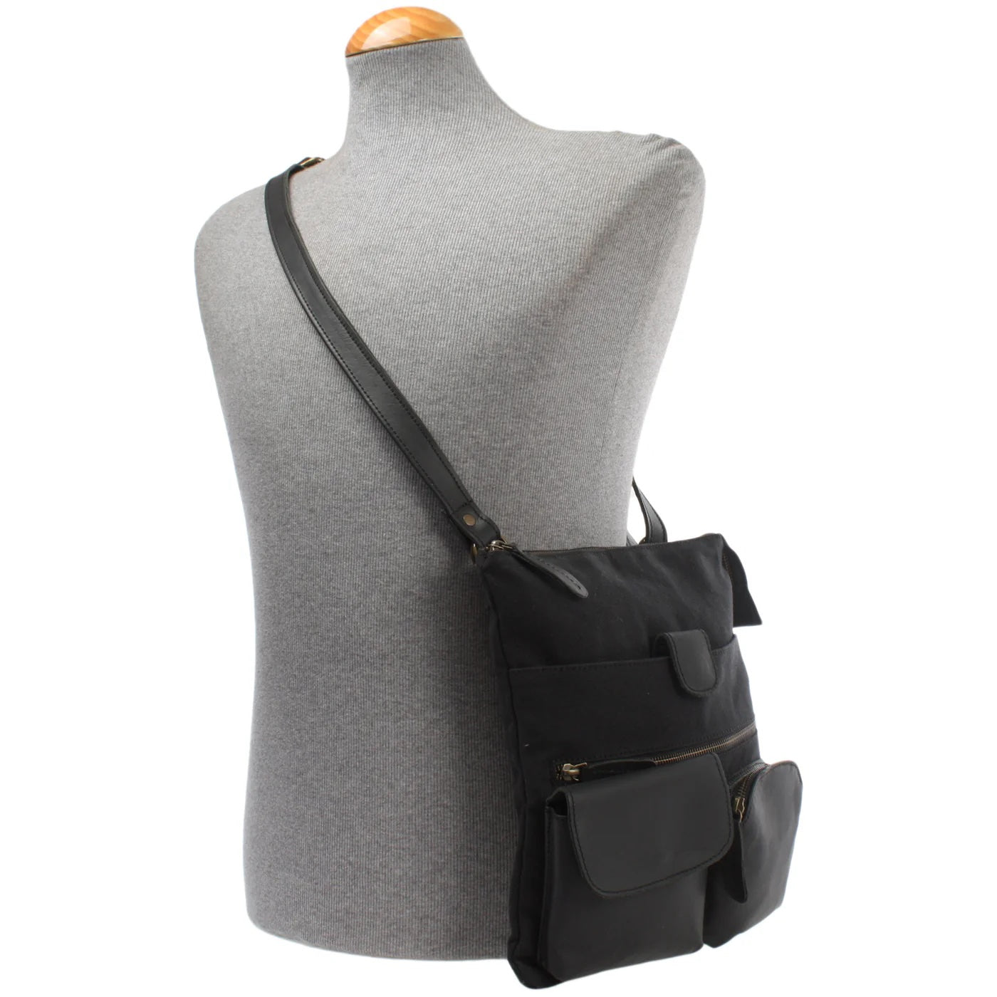 Black Arden canvas and cowhide crossbody bag worn on a mannequin, showing size and adjustable strap