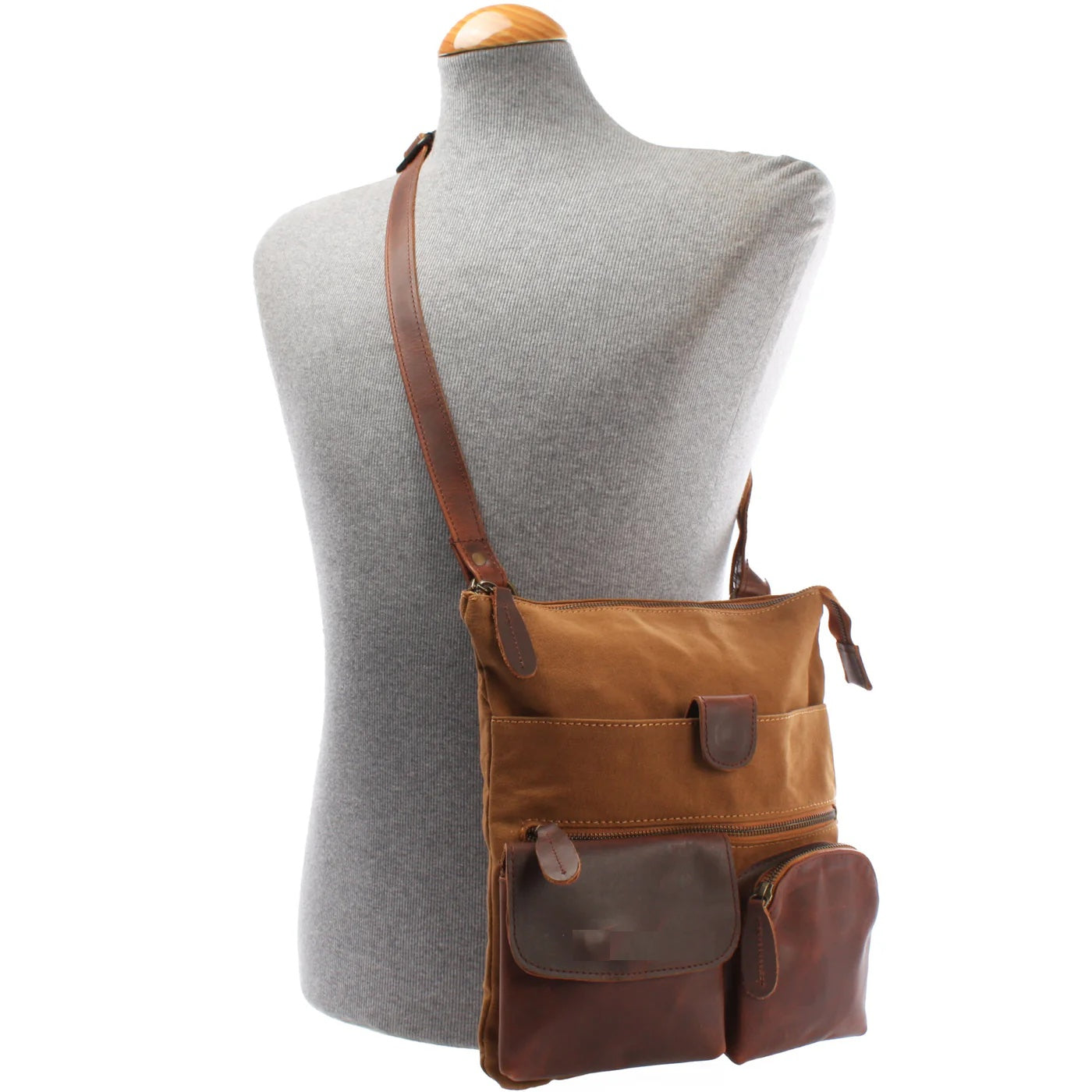 Cognac Arden canvas and cowhide crossbody bag worn on a mannequin, showing size and adjustable leather strap