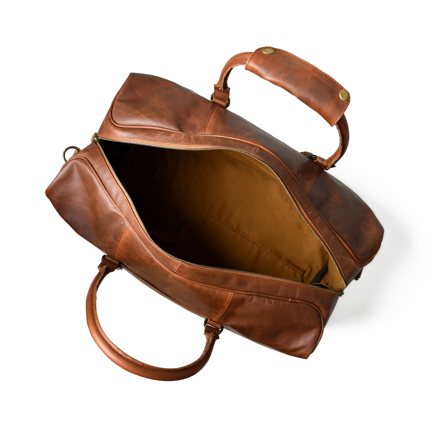 A brown leather duffel bag shown open from an overhead angle, revealing a tan interior lining and dual leather handles, photographed on a clean white background.