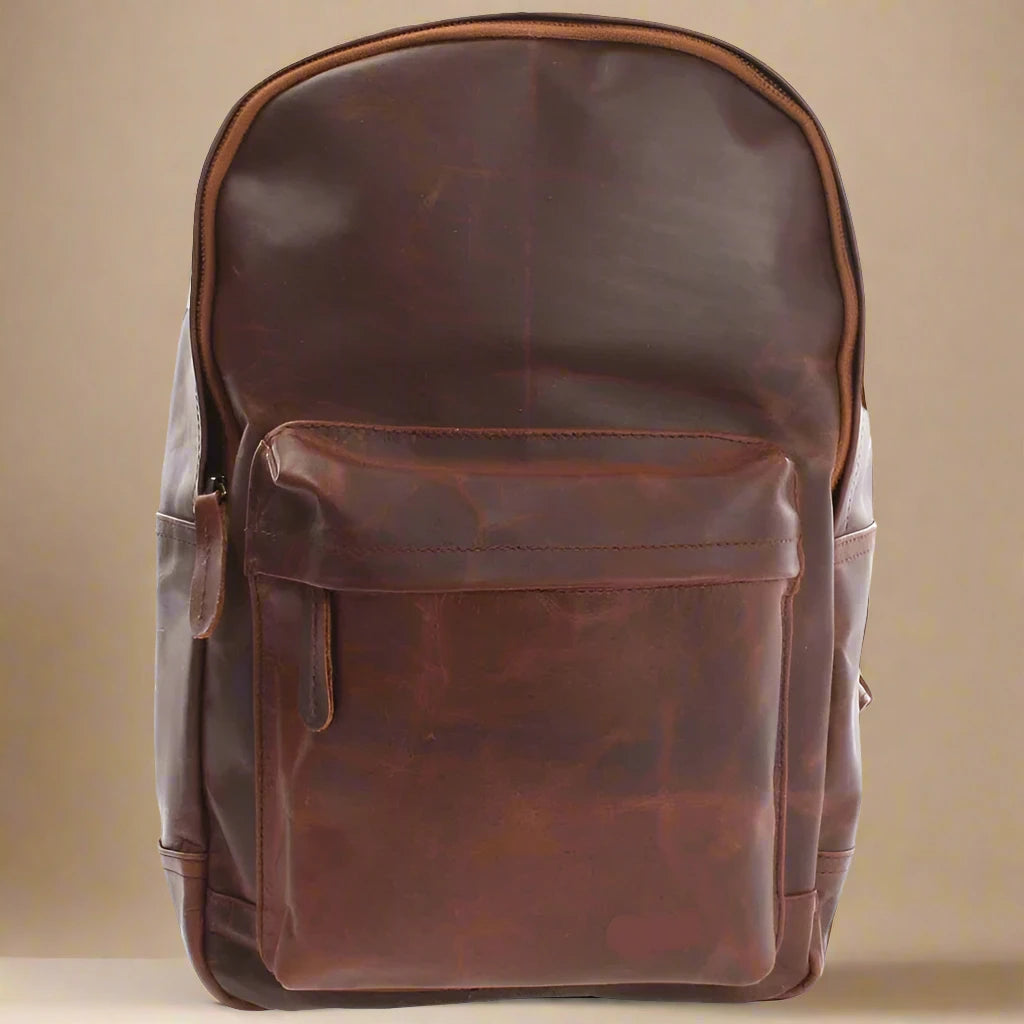 Brown Atlas waxed leather work backpack, front view with rounded top, zip opening, and large front pocket