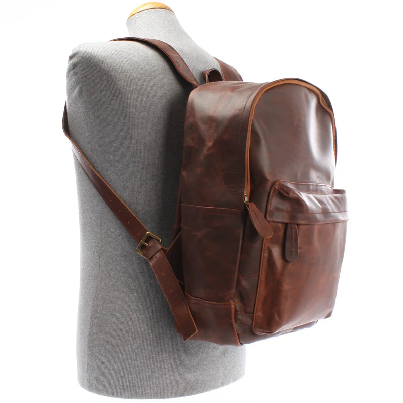 Brown Atlas waxed leather backpack worn on a mannequin, showing side profile and adjustable shoulder straps