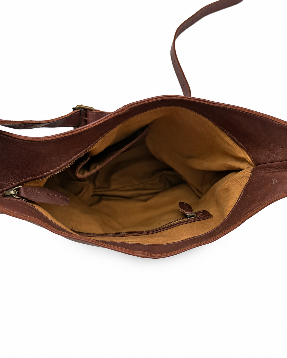 An open brown full-grain handmade leather shoulder bag showing its tan interior lining and zipper compartments, photographed on a clean white background.