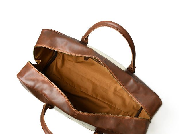 An open brown leather bag with a tan interior lining, shown from an overhead angle on a white background.