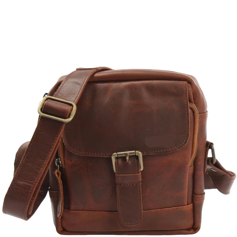 Brown Noa waxed leather crossbody bag, front view with distressed finish, flap, brass-tone buckle, and wide strap