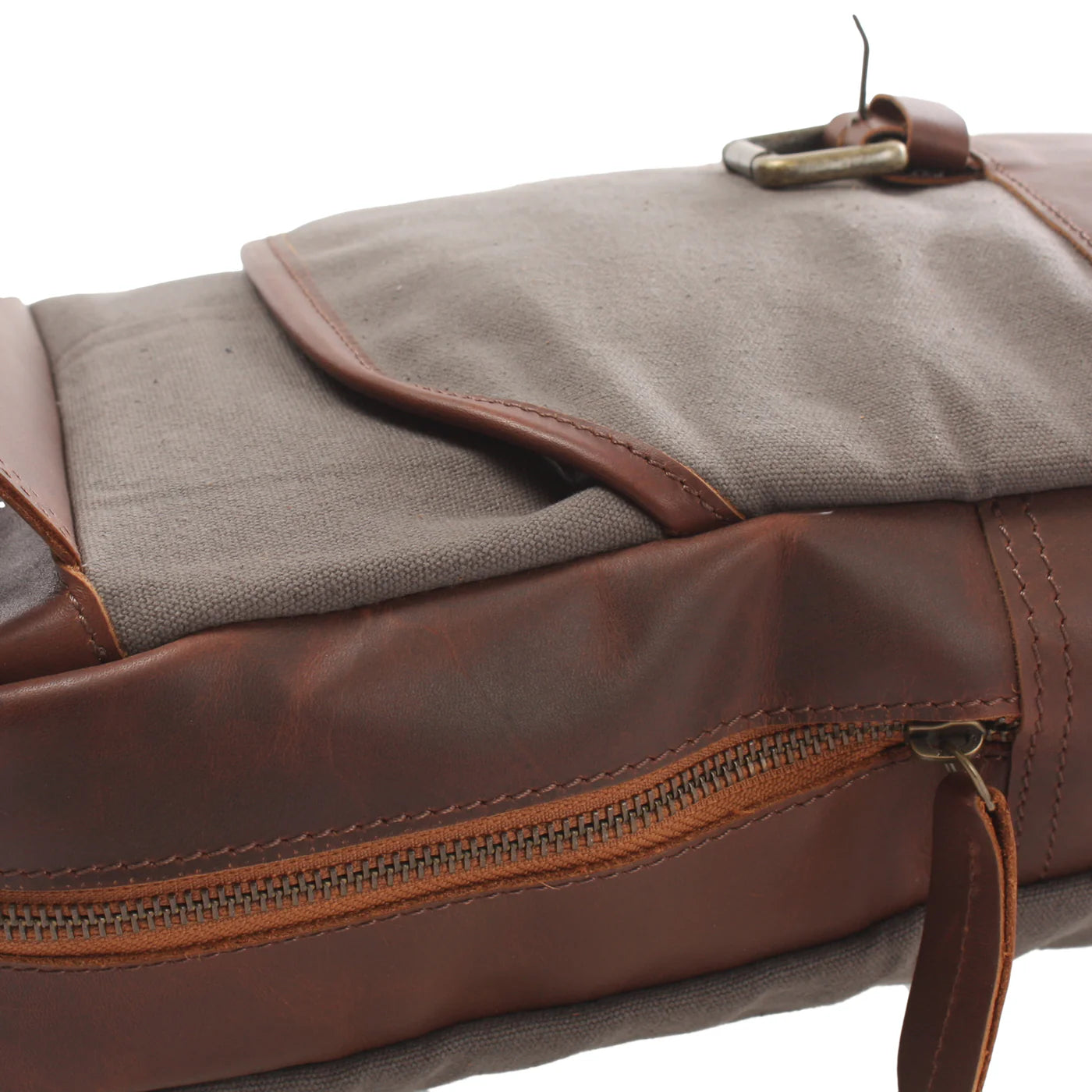 Close-up of gray Rowan canvas front pocket, brown leather trim, buckle, and main zipper