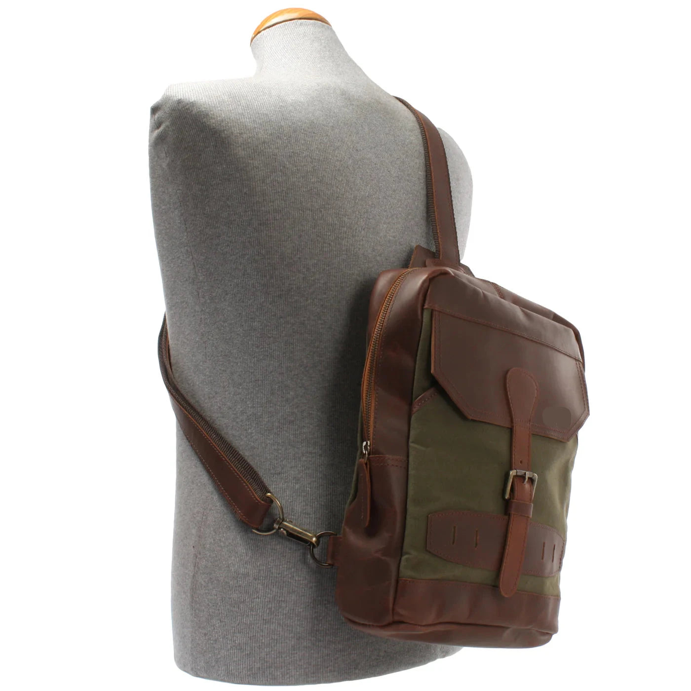 Olive green Rowan sling backpack worn crossbody on a mannequin, showing compact scale and adjustable strap