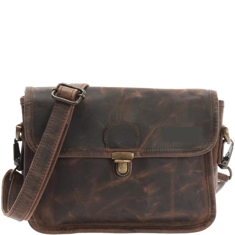 Dark brown Vela waxed leather shoulder bag, front view with flap, brass-tone clasp, and detachable strap
